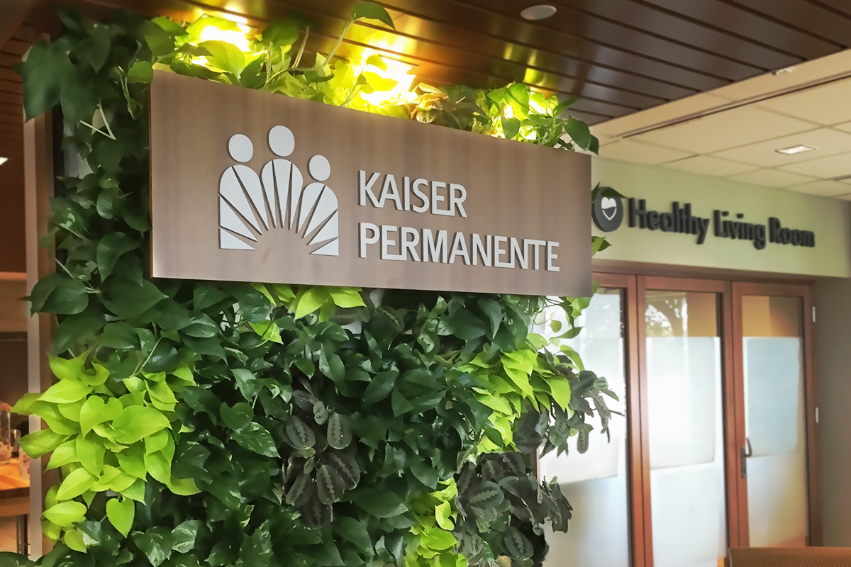 Tropicals in a living wall serve as a backdrop to a Kaiser Permanente health care sign.