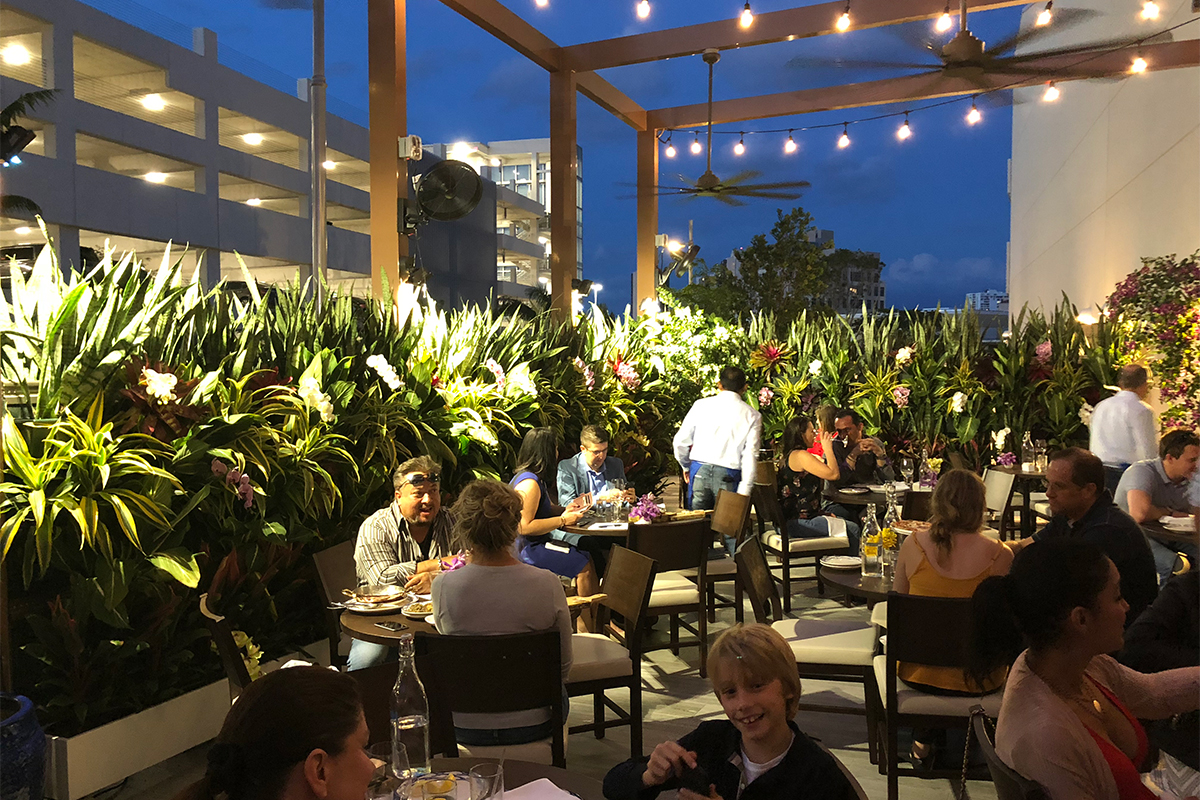 Outdoor dining area surrounded by LiveScreen's planted with tropical plants at Serafina Restaurant in Miami, Florida.