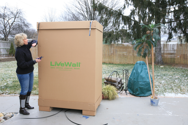 Woman removing packaging of mobile vertical garden system LiveScreen
