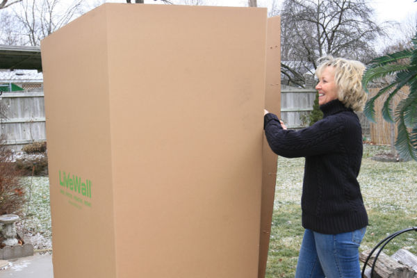 Woman opening box of mobile green wall LiveScreen