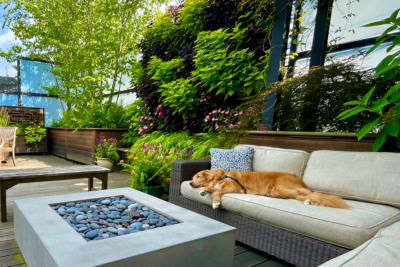 A colorful, vibrant living wall on a wood deck with patio furniture and fireplace.